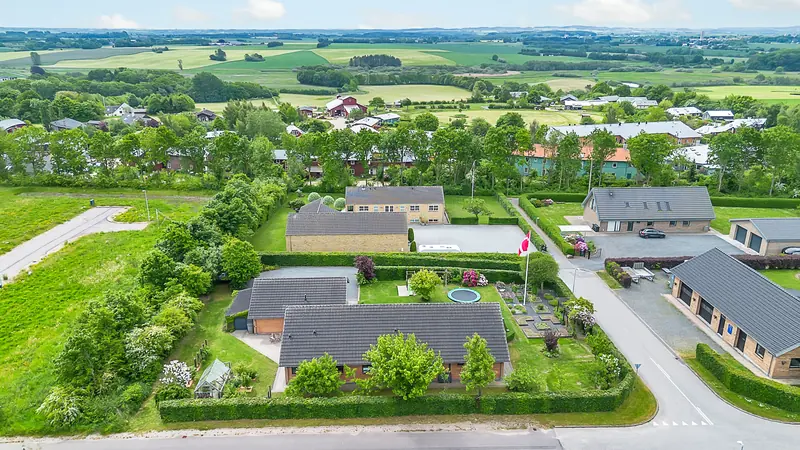 Luftfoto af grunden med huset, haven og de omkringliggende marker